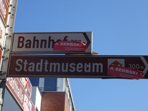Figure 13. Street sign in Cottbus with an activist sticker asking “What is it called in Sorbian?”, highlighting the absence of Sorbian from the city's public signage. Photo: Giustina Selvelli.